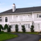 A large white house with a driveway in front of it.