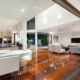 A living room with a glass wall and wooden floors